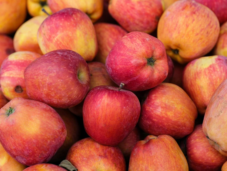 many red apples are piled on top of each other