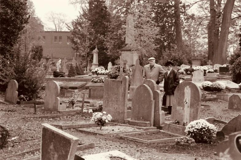 two men standing at the headstones of graves