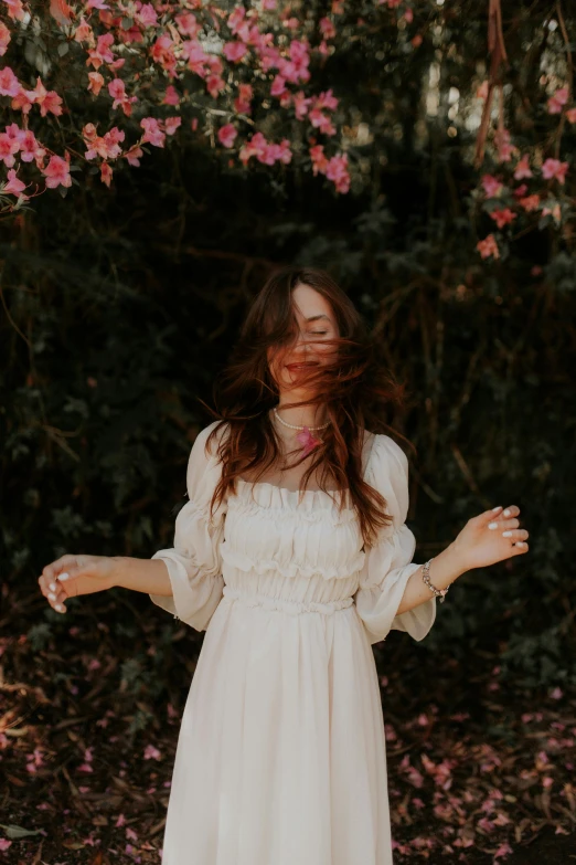 a woman in a white dress is standing and smiling