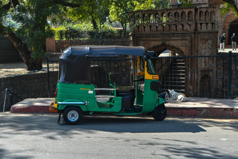 an old small green truck parked on a street