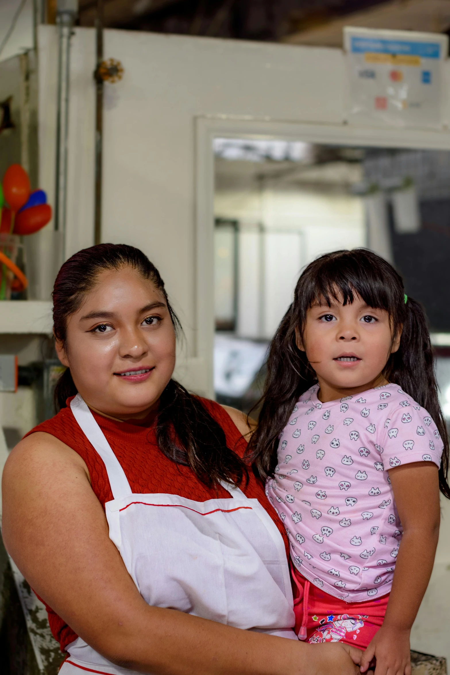 two women holding children, one in an apron