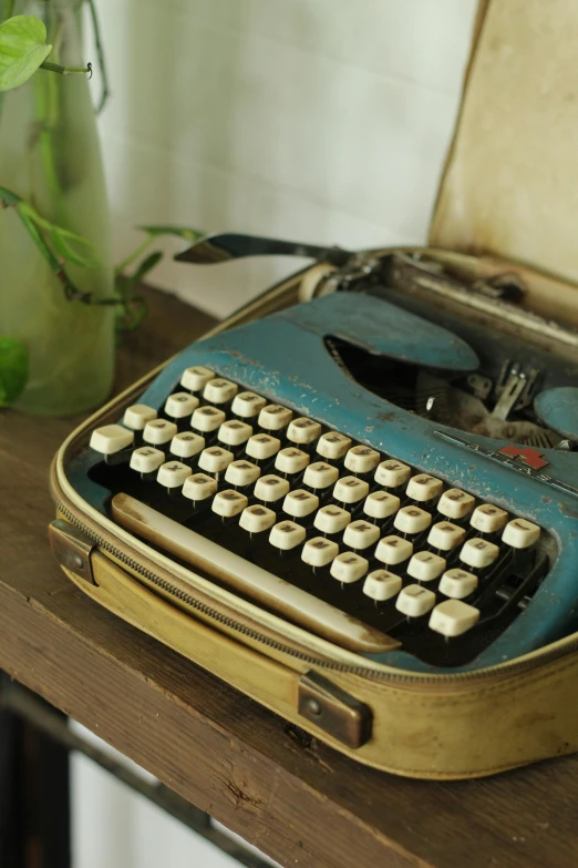 an old fashioned blue and white typewriter sitting on a table