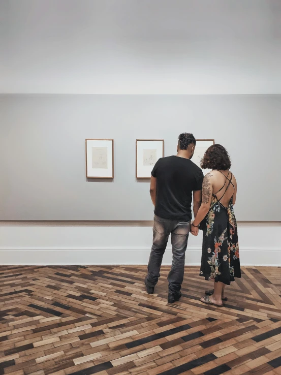 man and woman standing in art gallery with artwork