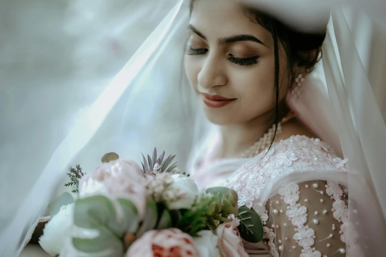 a woman in a wedding gown holds her bouquet