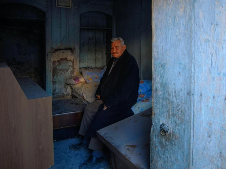 an older man sitting in his small room