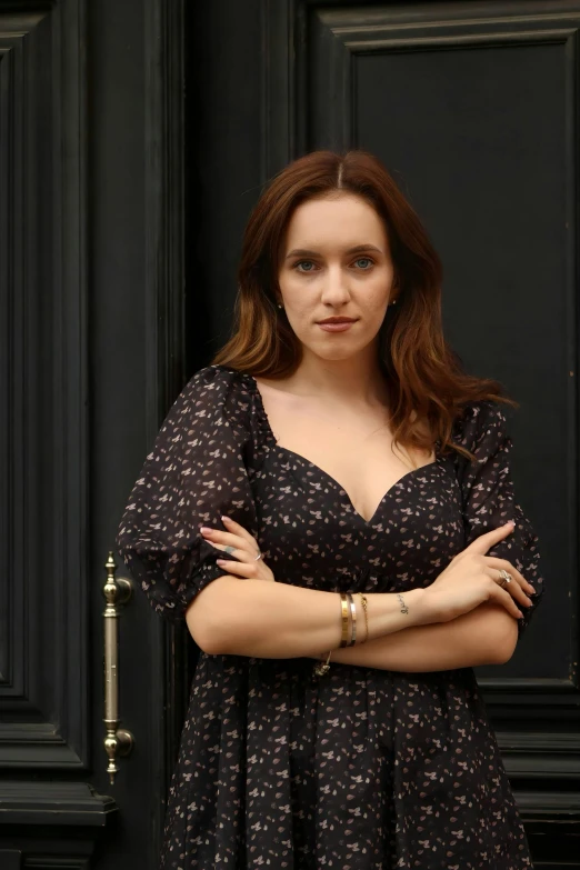 a beautiful woman posing next to black door