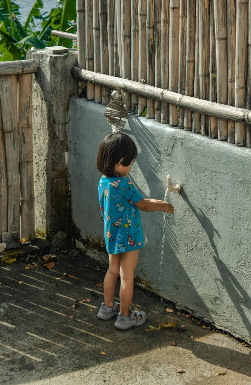 the child is playing with a bird on a post