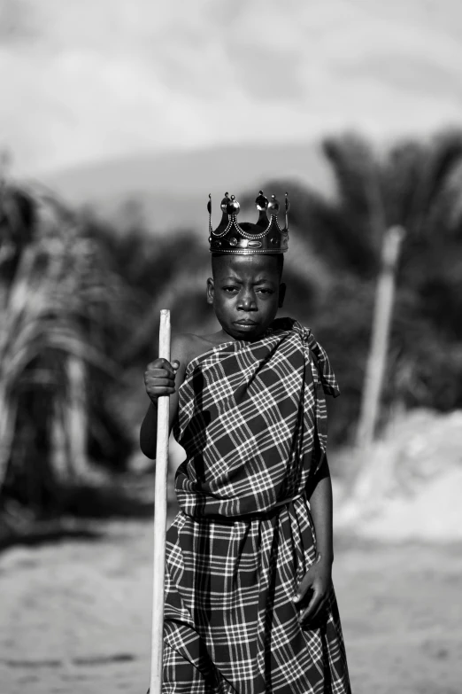 a woman wearing a crown holding a stick