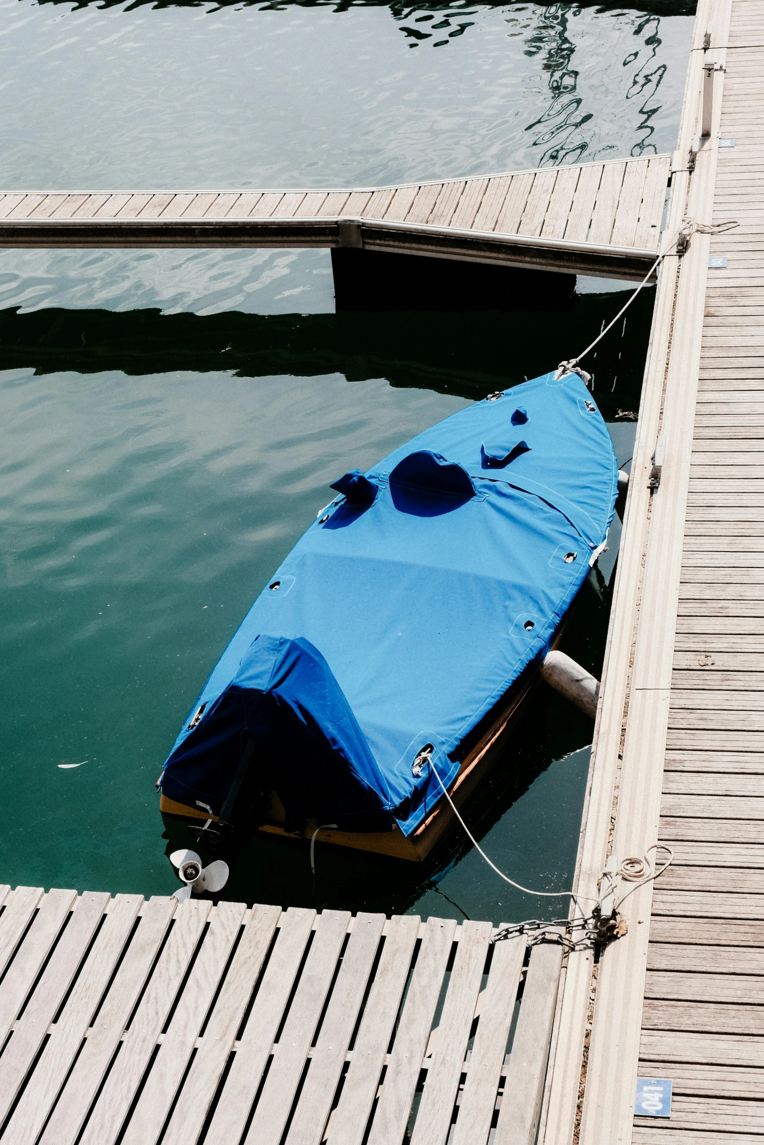 a blue raft with an umbrella floating on a lake