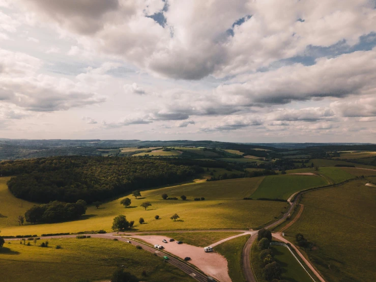 an aerial view of a dirt road surrounded by green hills