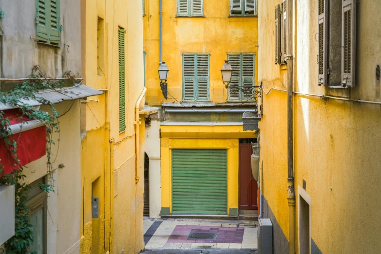 a narrow alley way with shuttered windows and green doors