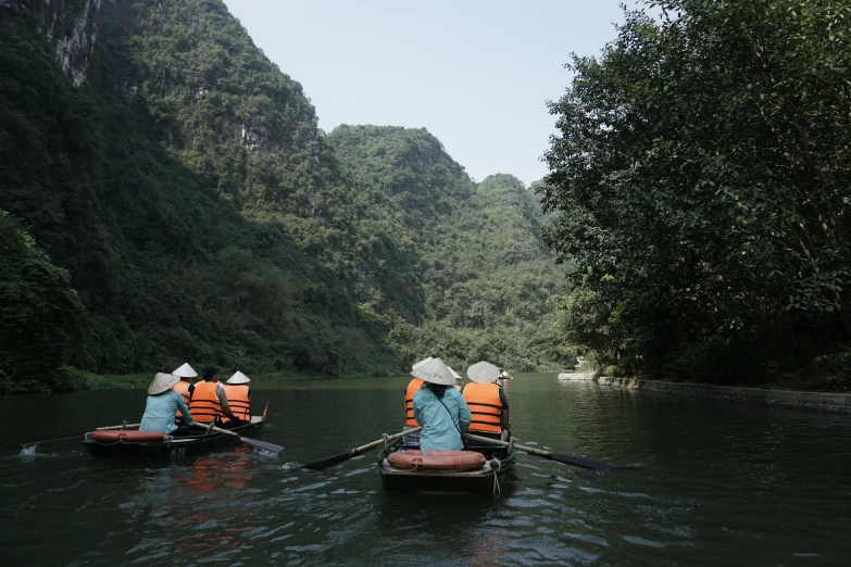 two boats travel down a river with many people on it