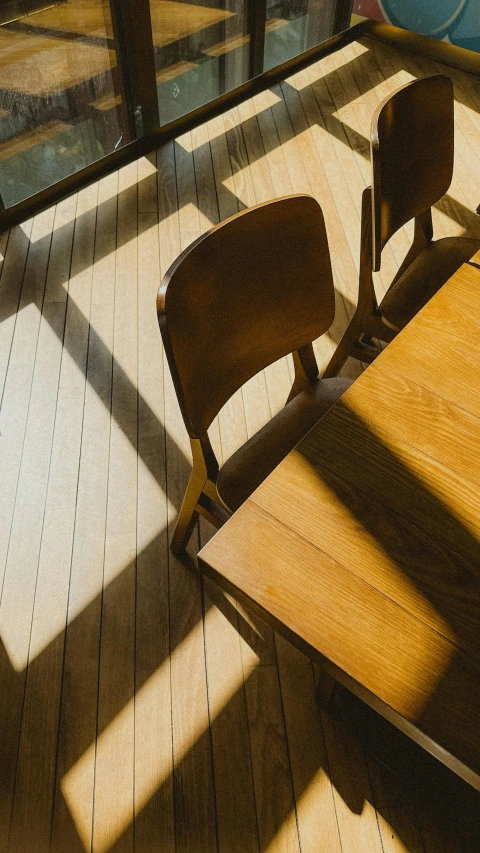 two wooden desks and chairs on a wood floor