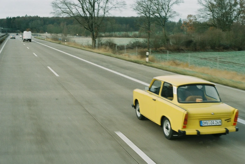 a yellow truck is traveling on the road