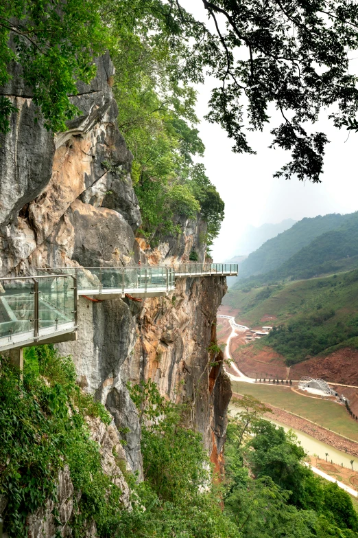 some people are looking over a bridge at a cliff