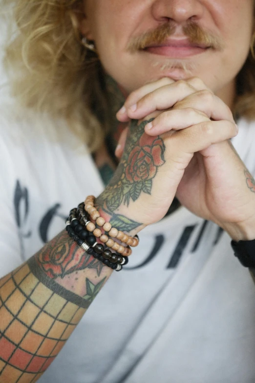 the woman is wearing a white shirt and has tattoos on her arms