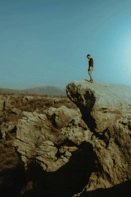 a person stands atop the side of a mountain