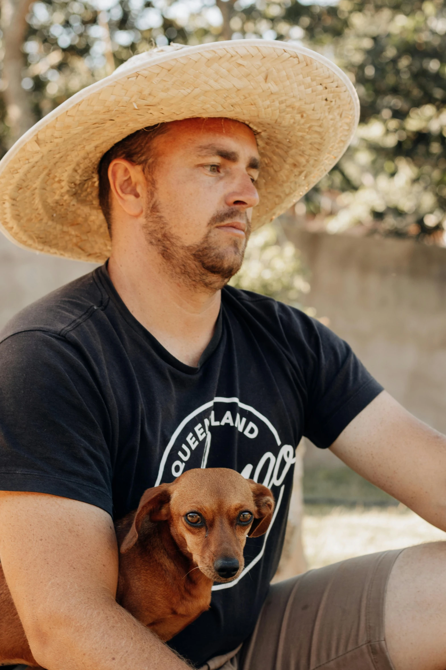 a man is sitting down and holding a dog