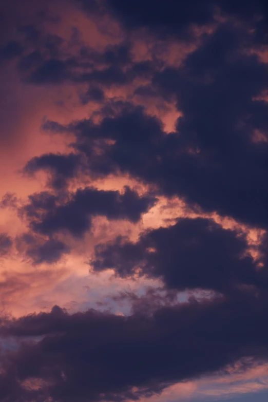 a large group of clouds are shown against a pink sky