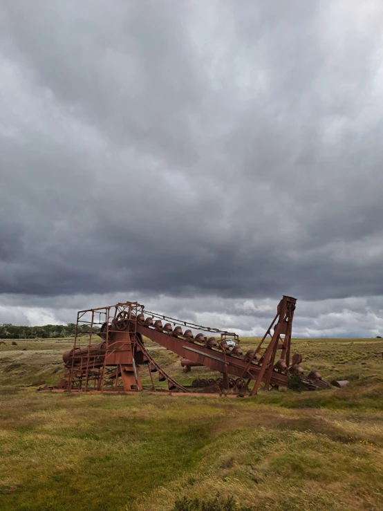 an old rusted out building sitting in a field