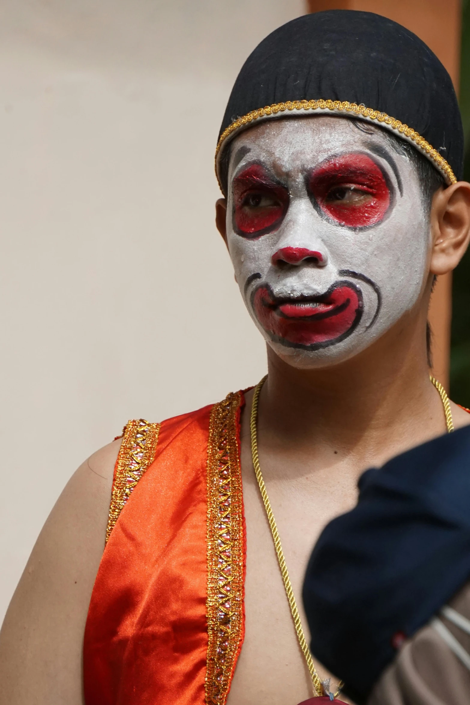 a person wearing red and white paint painted on their face