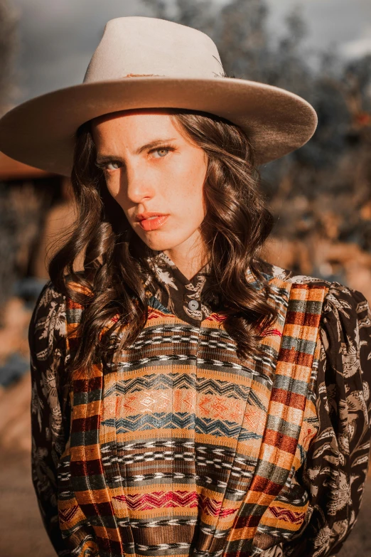 a girl in a plaid top and hat posing for the camera