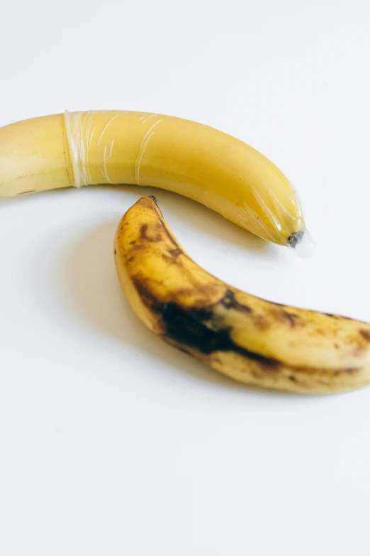 two bananas on a white background that appear to be eaten
