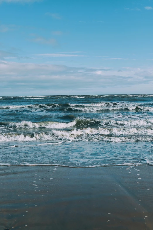 a person holding an umbrella standing on the beach