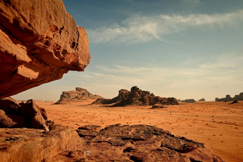 an area with rocks and sand, with a blue sky in the background