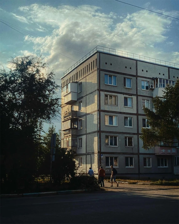 some people are walking near a large building