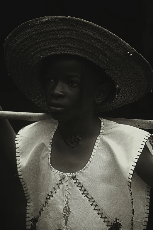 a woman in a sun hat stands near an arm chair