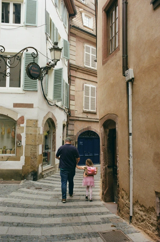 man and child walking down stairs with buildings on either side