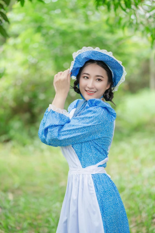 a young woman poses for the camera while wearing a blue hat and blue dress