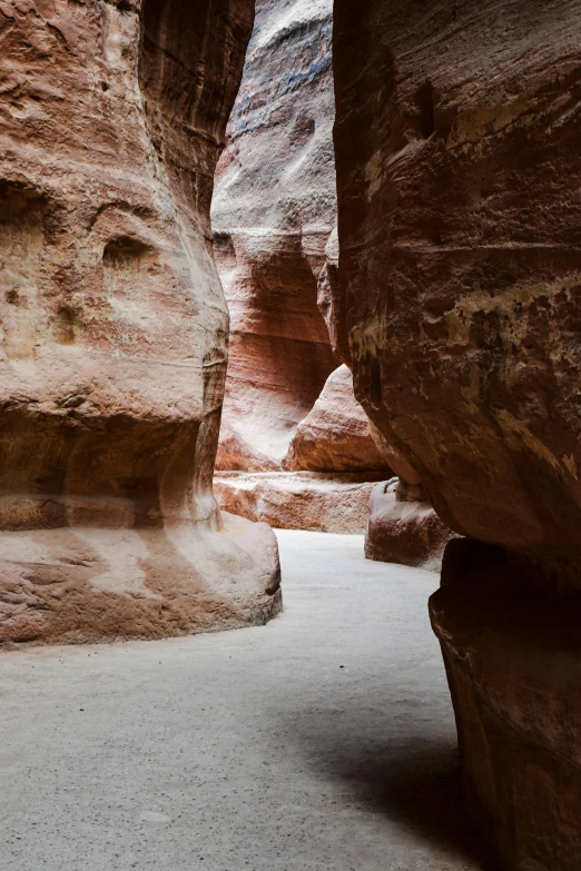 a man stands in between two very narrow stone cliffs