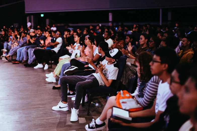 several people sitting down and listening to someone