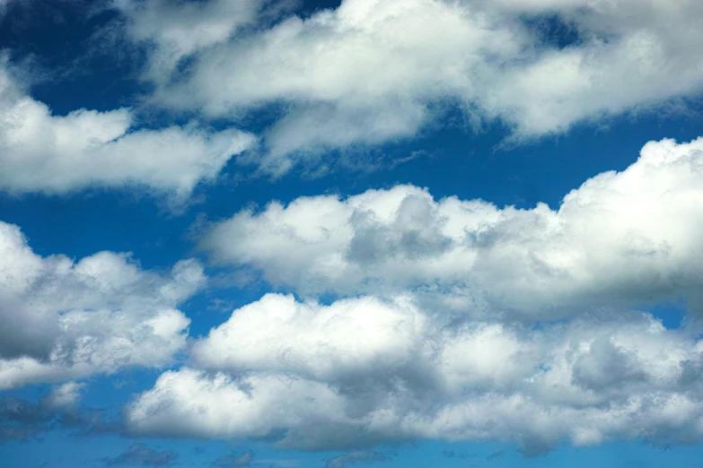 a lone plane is flying under the bright blue sky