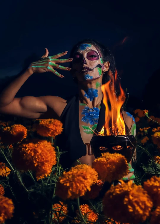 a person covered in body paint and face paint standing in flowers