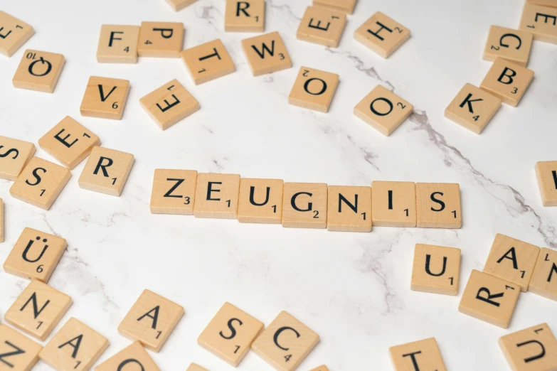 scrabbled scrabble tiles with the words zeugn is spelled out