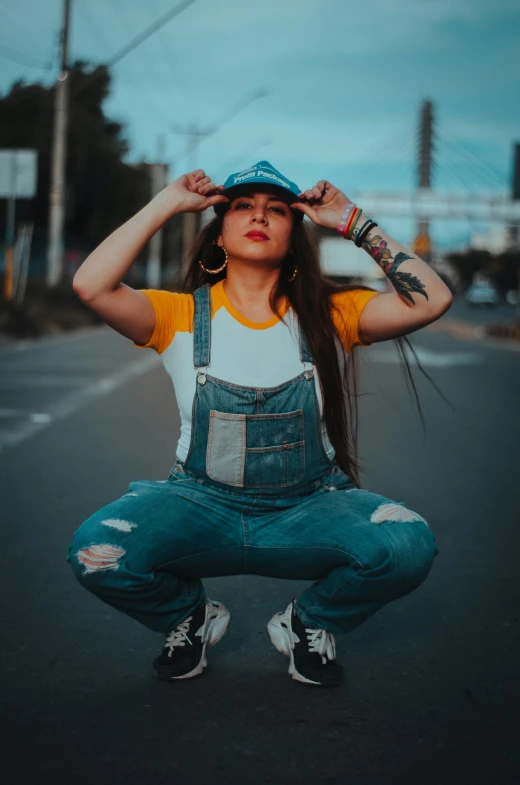 woman crouched on the ground holding up her hat