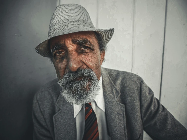 an older man with a hat, suit and tie