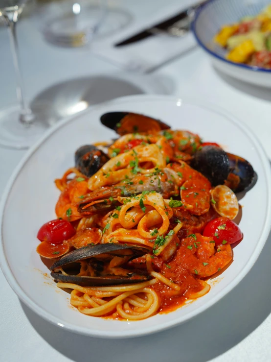 a plate of spaghetti, shells and vegetables