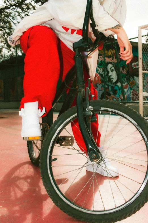 a man riding on the back of a bike wearing red pants