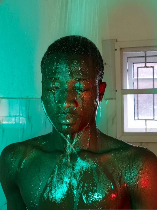 a man covered in green colored liquid sitting on the floor