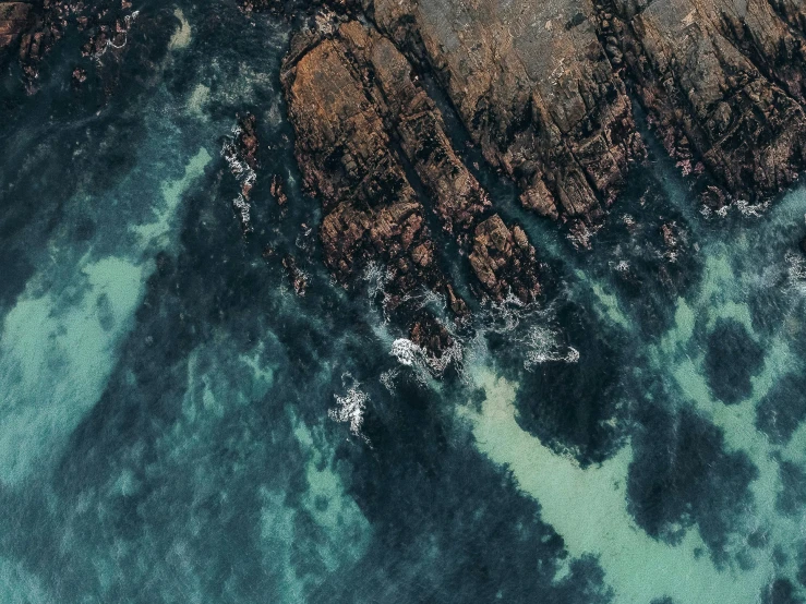 the aerial view shows the ocean, rocks and land