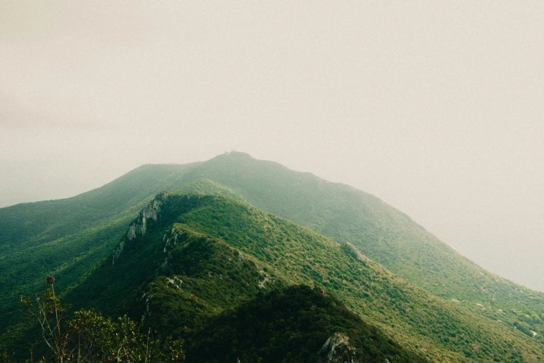 a view of some mountains that have green foliage on them