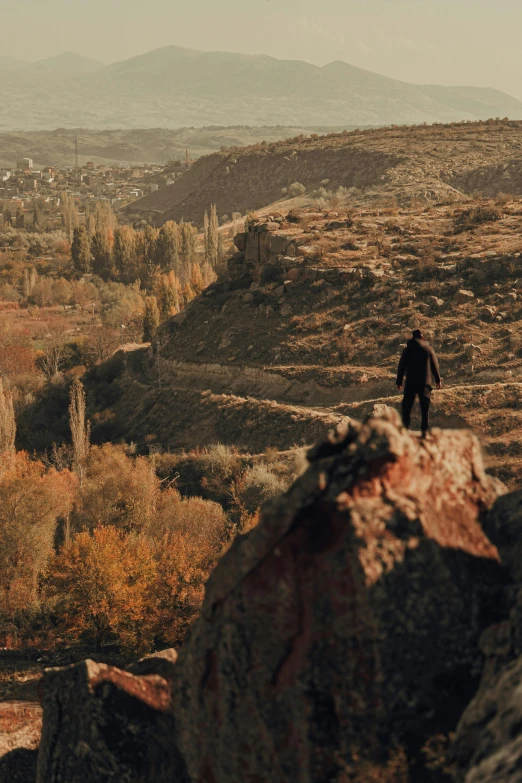 a lone person standing on top of a cliff