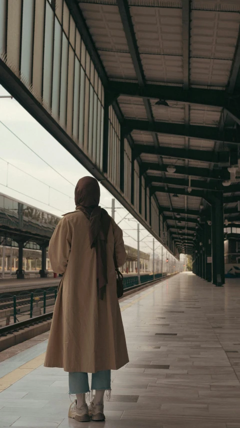 a person walking into a train station as the train rolls by