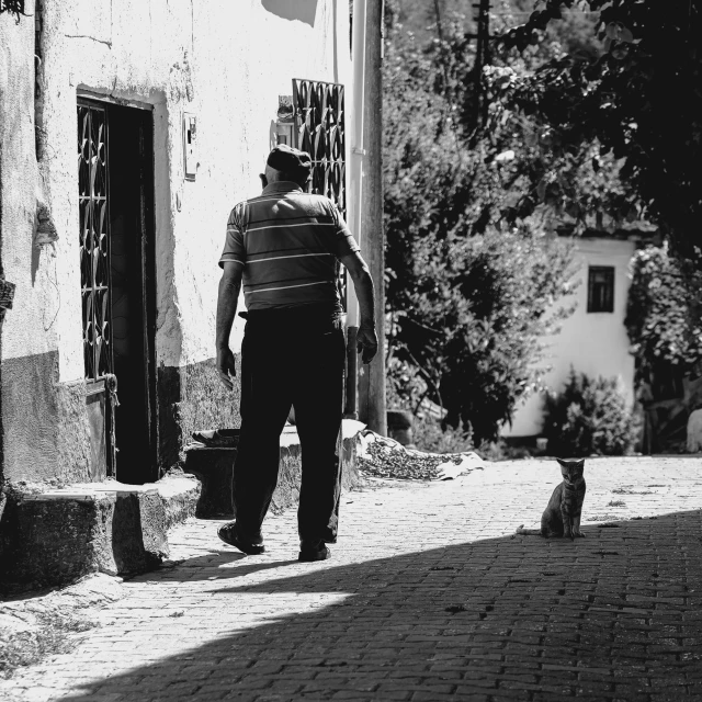 a black and white po of a man walking down a sidewalk