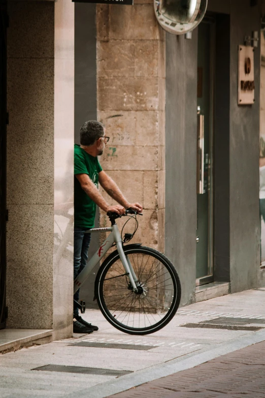 man standing next to a bicycle in an alley