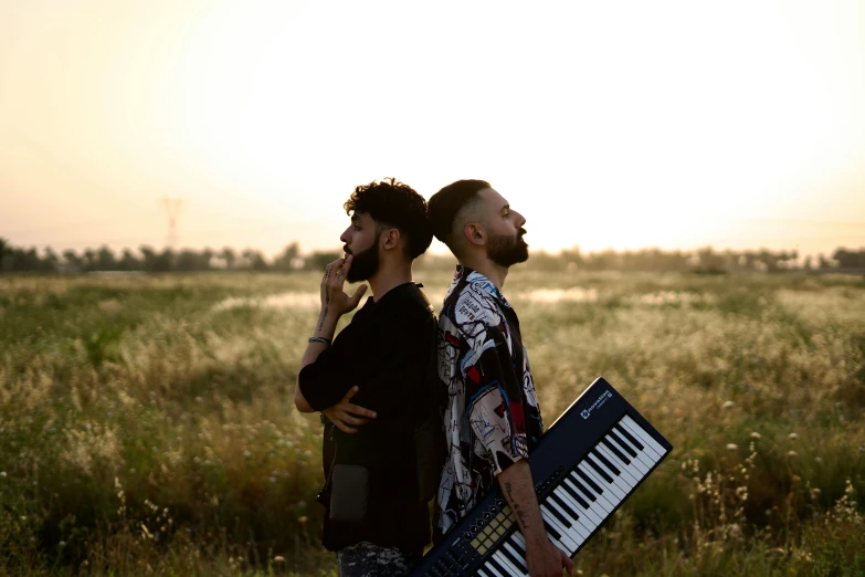 two people stand near each other in front of an open field with an organ